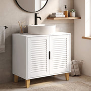 Cabinet under a bowl basin beside a towel rail and a wire basket