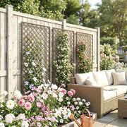 Trellis panels fixed to a garden fence beside a rattan sofa and flowering border