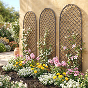 Three trellis panels mounted on a cream stucco wall above a colourful flower bed
