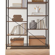 Close-up of two shelf columns holding upright books and lidded storage boxes