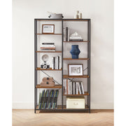 Bookcase against a white wall with magazines, books and a blue vase on display