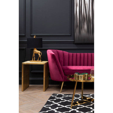 Wine velvet sofa styled in a furnished living room setting