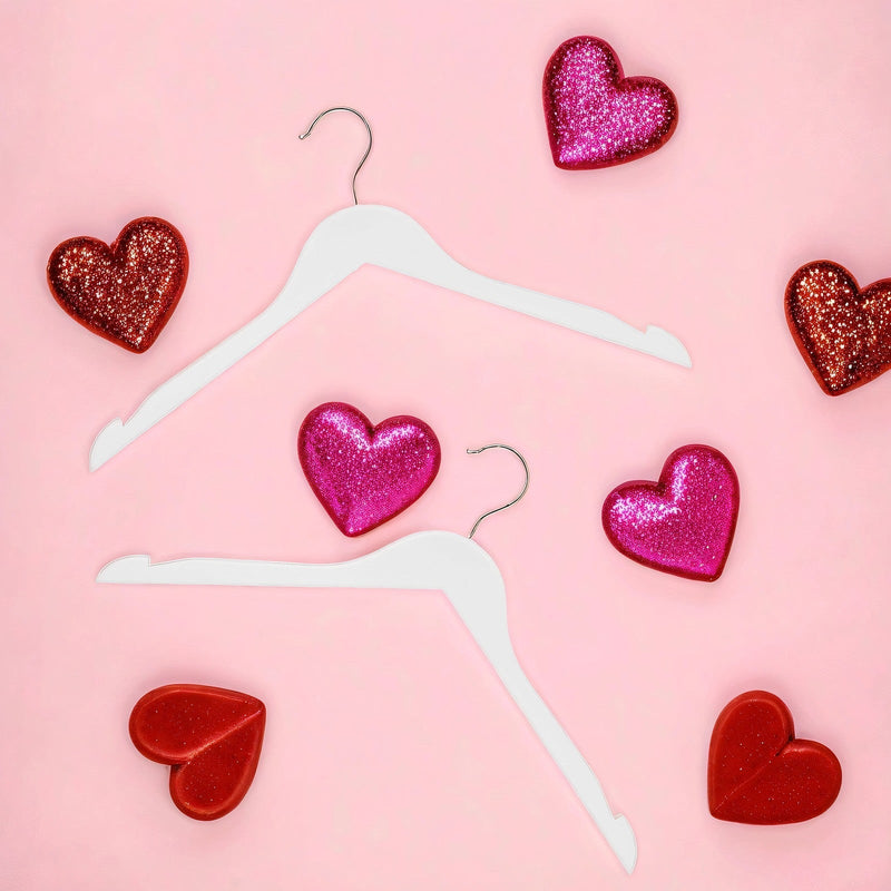 White wood clothes hangers styled flat-lay with heart decorations