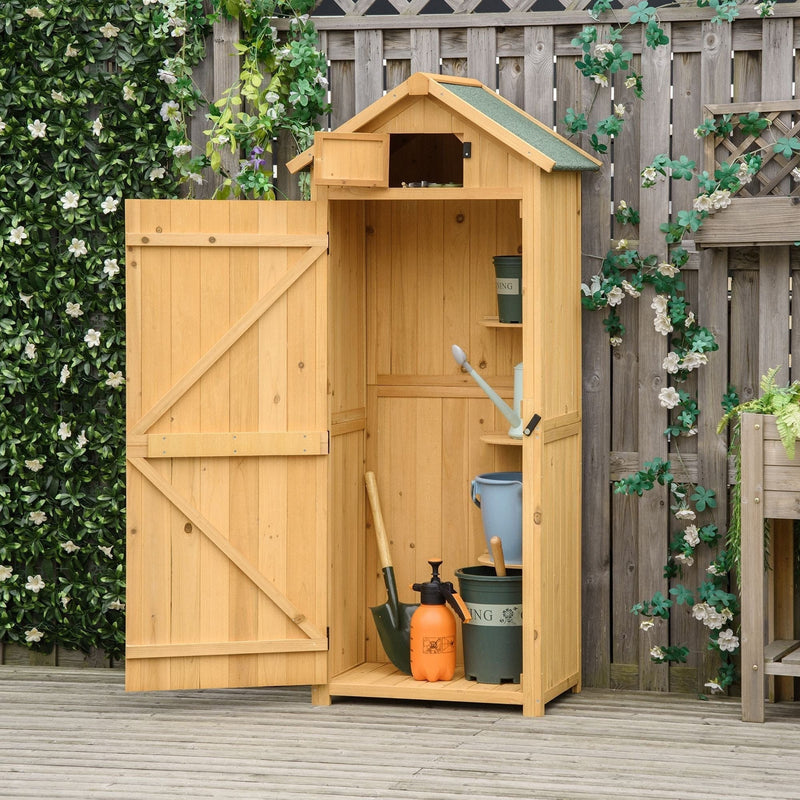 Natural wood sentry box shed open in a garden with a watering can and tools inside