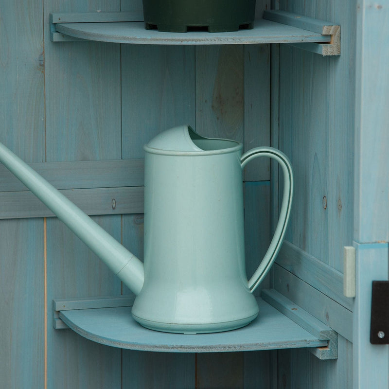 Watering can resting on a quarter-round shelf inside the blue sentry box shed