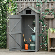 Grey wooden sentry box shed with its door open in a garden, tools and pots stored inside