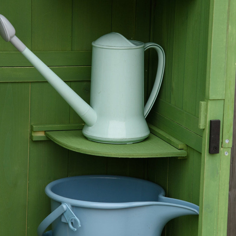 Watering can on a corner shelf and a bucket below inside the green shed