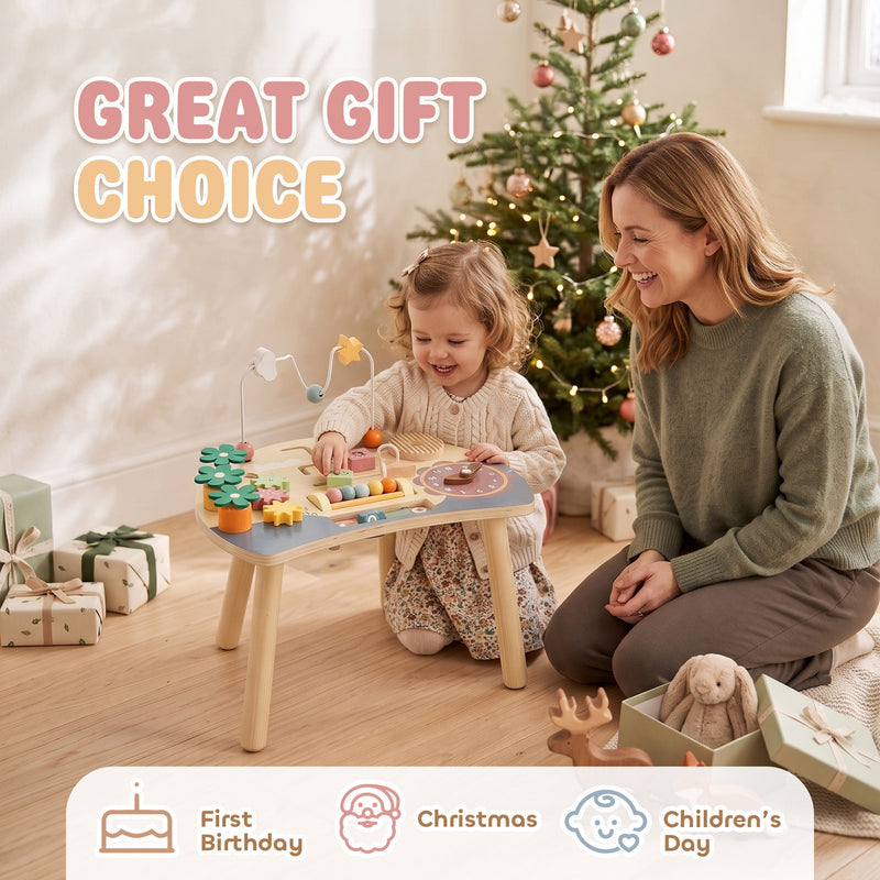 Parent and toddler playing at the activity table beside a Christmas tree