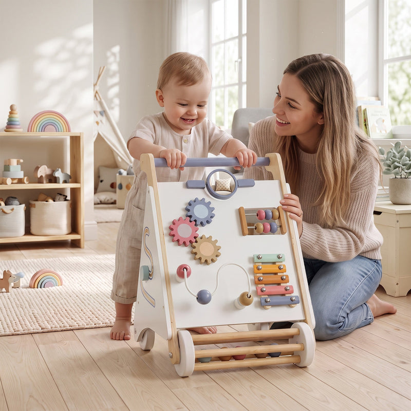 Mother helping a baby push the wooden baby walker across a living room floor