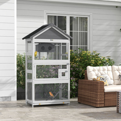 PawHut wooden bird cage on an outdoor patio beside garden furniture