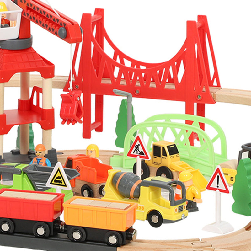 Close-up of the train wagons and construction vehicles beneath the red bridge