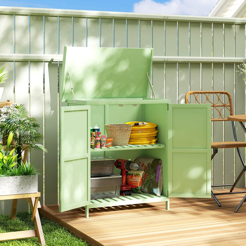 Light green shed on a decked patio with the lid raised and doors open showing a hose and tins