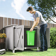 Man placing a green wheelie bin into the open light grey garden storage shed