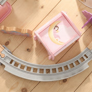 Close-up of a pink castle piece beside grey curved train track