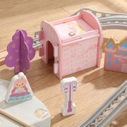 Close-up of a pink castle tower with a purple tree, princess figure and lamp post