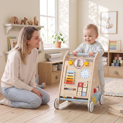 Toddler pushing the wooden baby walker while a parent watches nearby