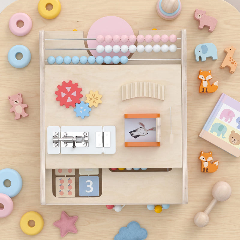 Flat-lay close-up of the activity board's abacus, gears, lock-and-latch and image-flip panel