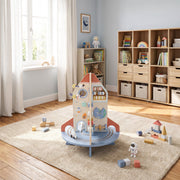 Rocket activity centre in a playroom with scattered blocks and shelving behind