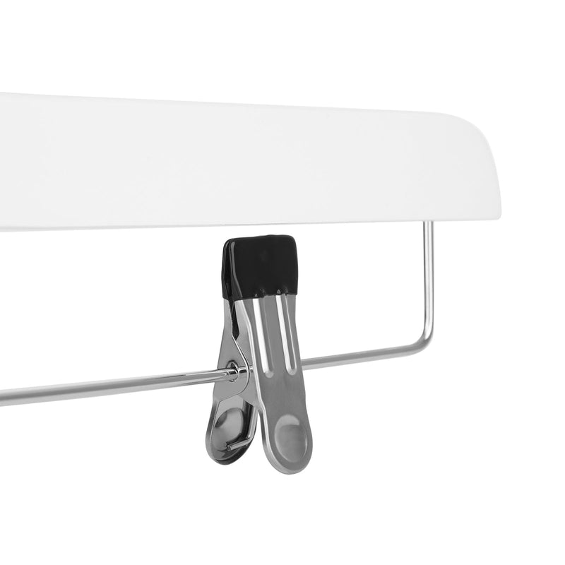 Extreme close-up of one chrome clip and its black grip pad on a white hanger bar