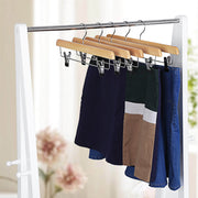 Natural wooden hangers on a chrome rail holding navy, tan and blue skirts