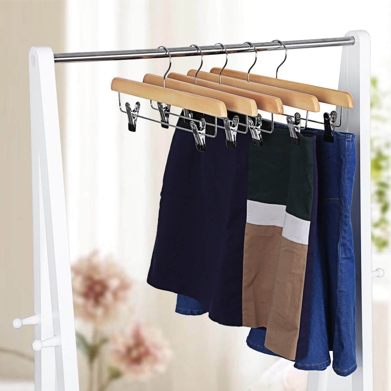 Natural wooden hangers on a chrome rail holding navy, tan and blue skirts
