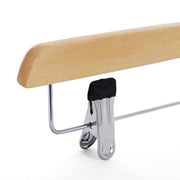 Close-up of a metal clip with a black grip pad on a natural wooden hanger