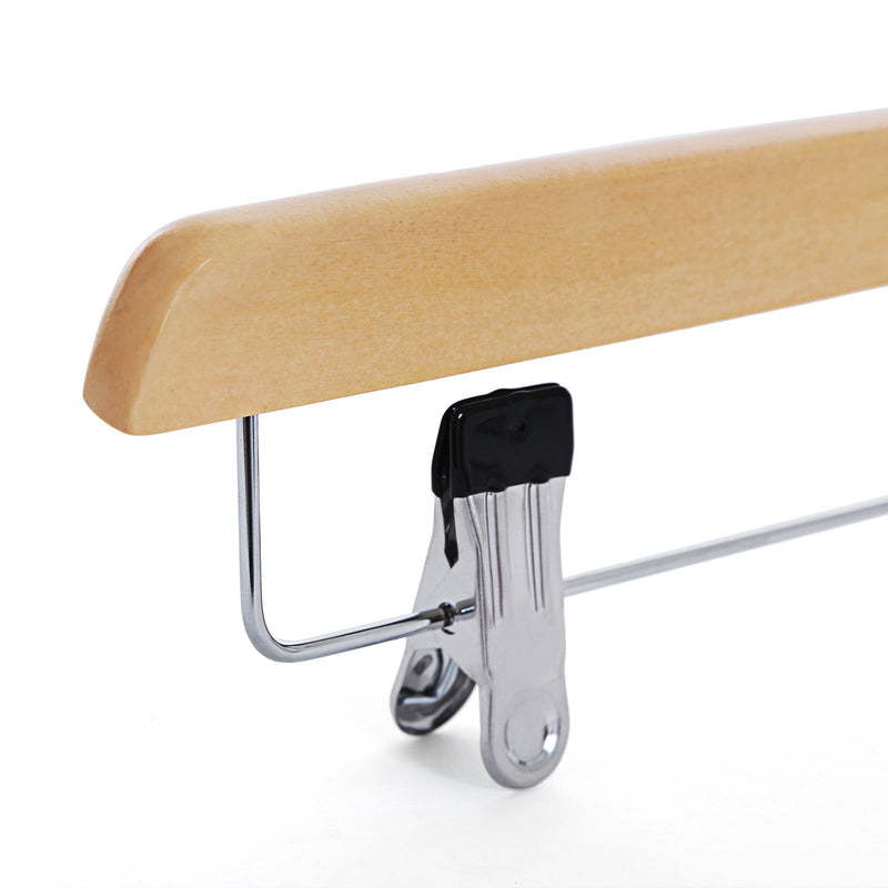 Close-up of a metal clip with a black grip pad on a natural wooden hanger