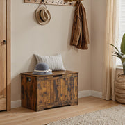 Rustic brown storage bench styled in an entryway beneath a coat rack