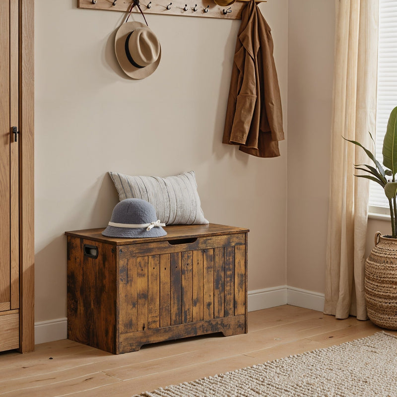 Rustic brown storage bench styled in an entryway beneath a coat rack