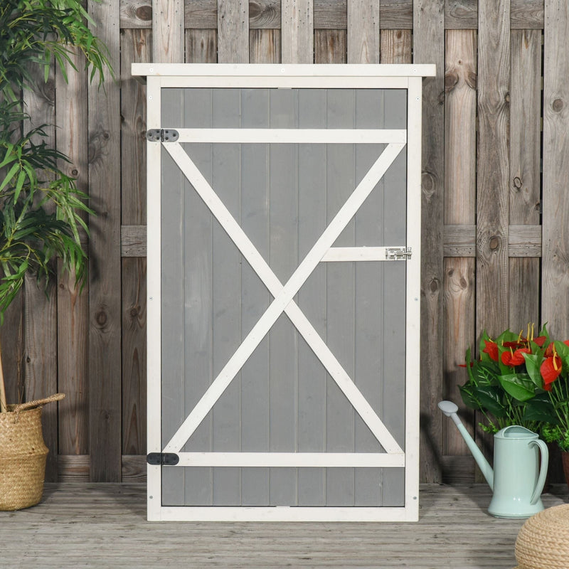Grey wooden garden shed standing closed against a rustic timber fence