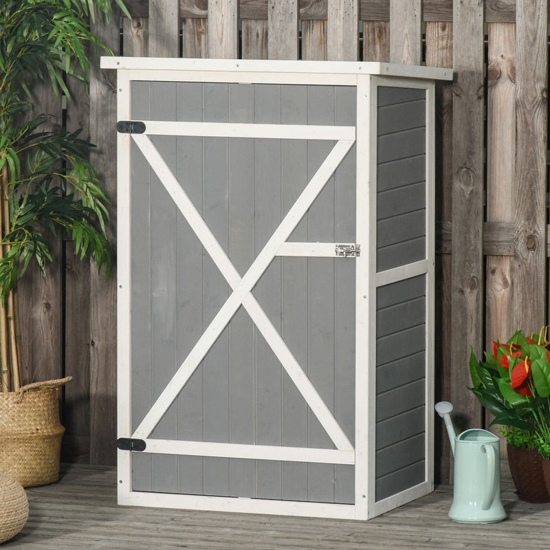 Grey wooden garden shed beside a fence with a watering can and plants