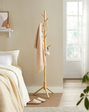 Wooden tree coat rack styled in a hallway with coats hanging