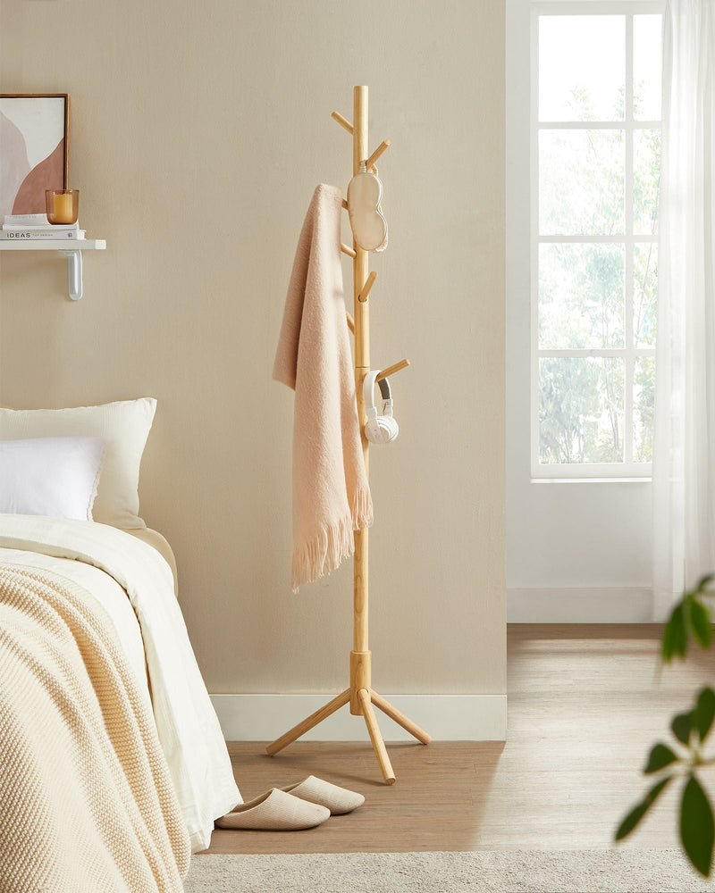 Wooden tree coat rack styled in a hallway with coats hanging