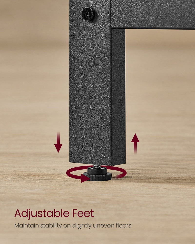 Close-up of the threaded levelling foot at the bottom of a black steel desk leg on a wooden floor