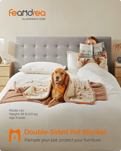 Lifestyle shot of the Feandrea double-sided pet blanket draped on a sofa with a dog