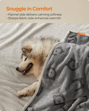 Close-up of a dog snuggled in the reversible sherpa and flannel sides of the blanket
