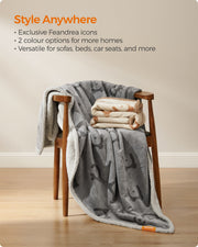 Folded Feandrea dog blanket in grey and beige colour options styled on a wooden chair