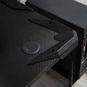 Close-up of the tabletop corner with a cable hole cover and a PC tower alongside