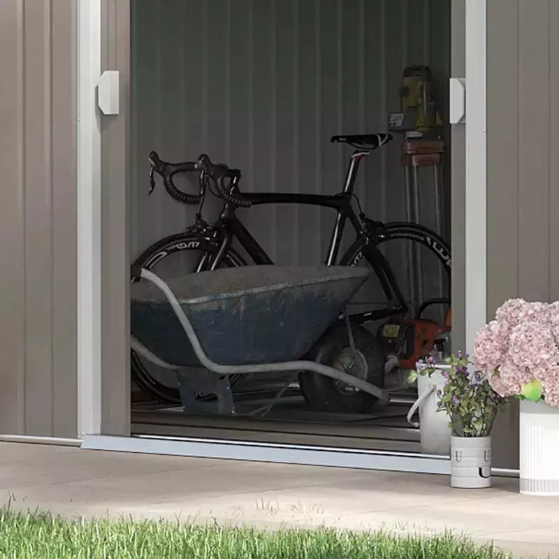 Interior view through the open doors with a road bike and wheelbarrow stored inside