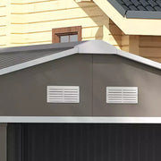 Close-up of two white louvred ventilation panels set into the light grey shed gable