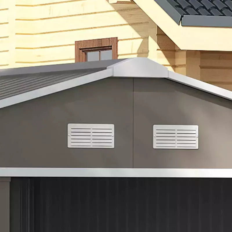 Close-up of two white louvred ventilation panels set into the light grey shed gable