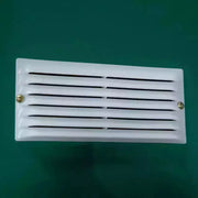 Close-up of a white louvred ventilation panel fitted to the green shed wall
