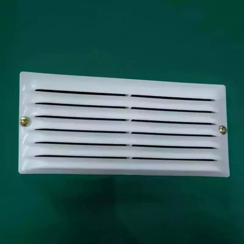 Close-up of a white louvred ventilation panel fitted to the green shed wall