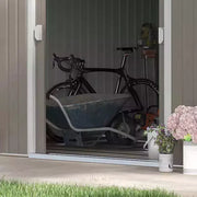 Interior view of the shed with a road bike and wheelbarrow stored inside