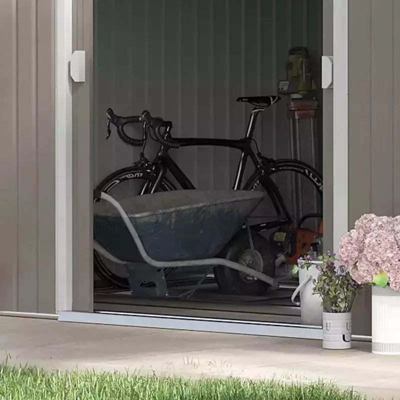 Interior view of the shed with a road bike and wheelbarrow stored inside