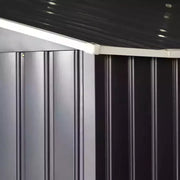 Close-up of the ribbed dark grey steel panels running up to the roof line